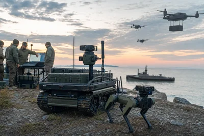 Équipe militaire supervisant un véhicule terrestre, un chien-robot, des drones et un navire sans équipage lors d’un exercice côtier